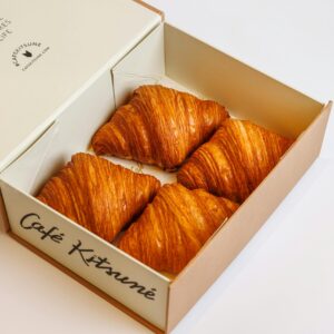 Freshly baked croissants in a stylish Café Kitsuné box, perfect for breakfast.
